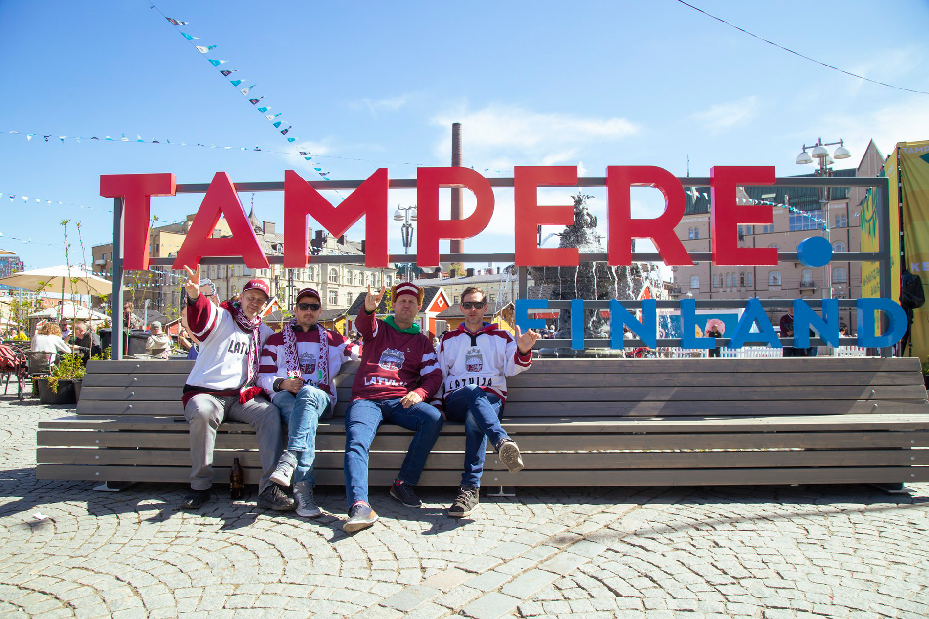 A group of friends posing next to a Tampere Finland sign.