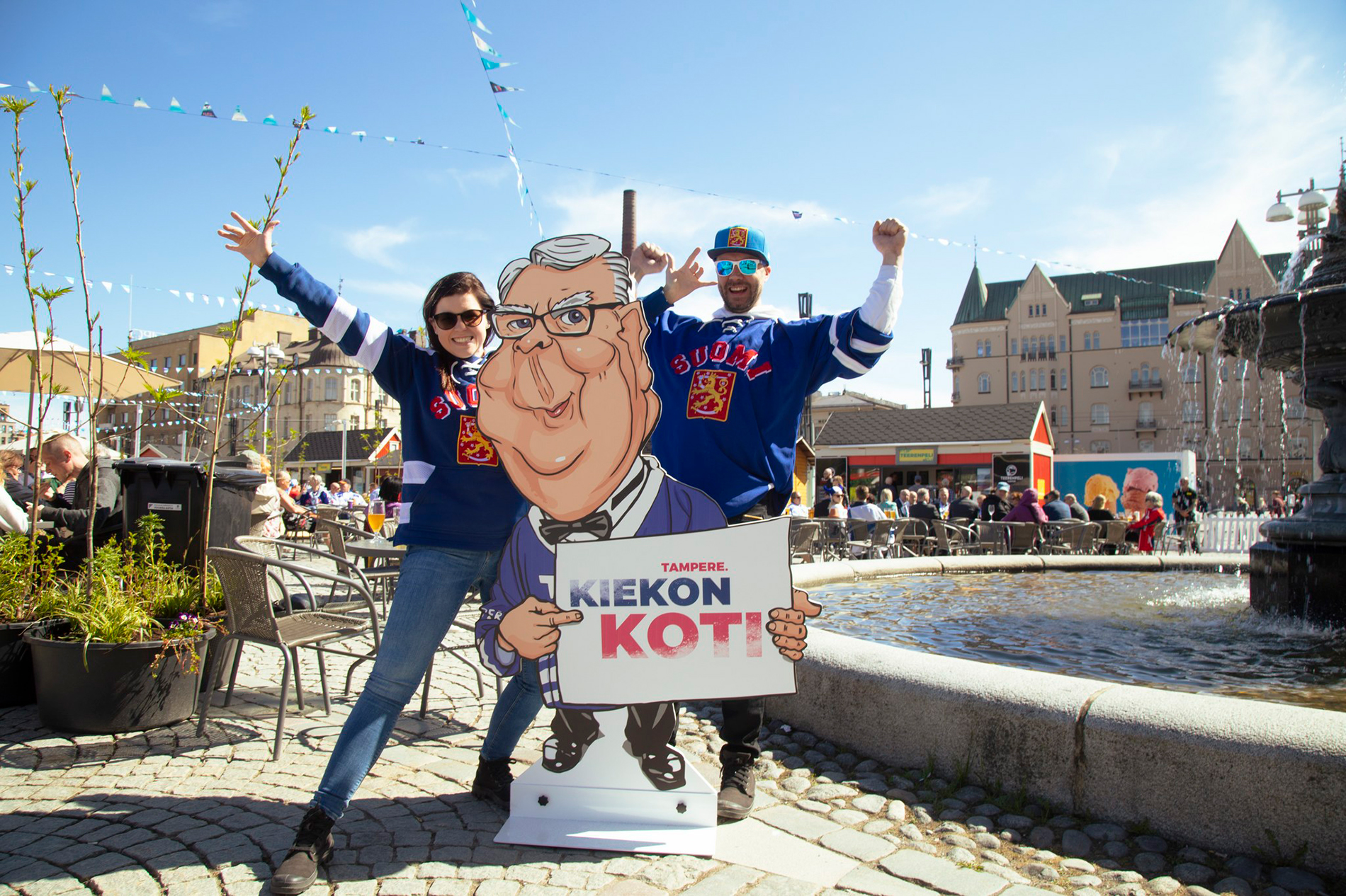 Two people posing next to Home of Hockey cardboard figure.