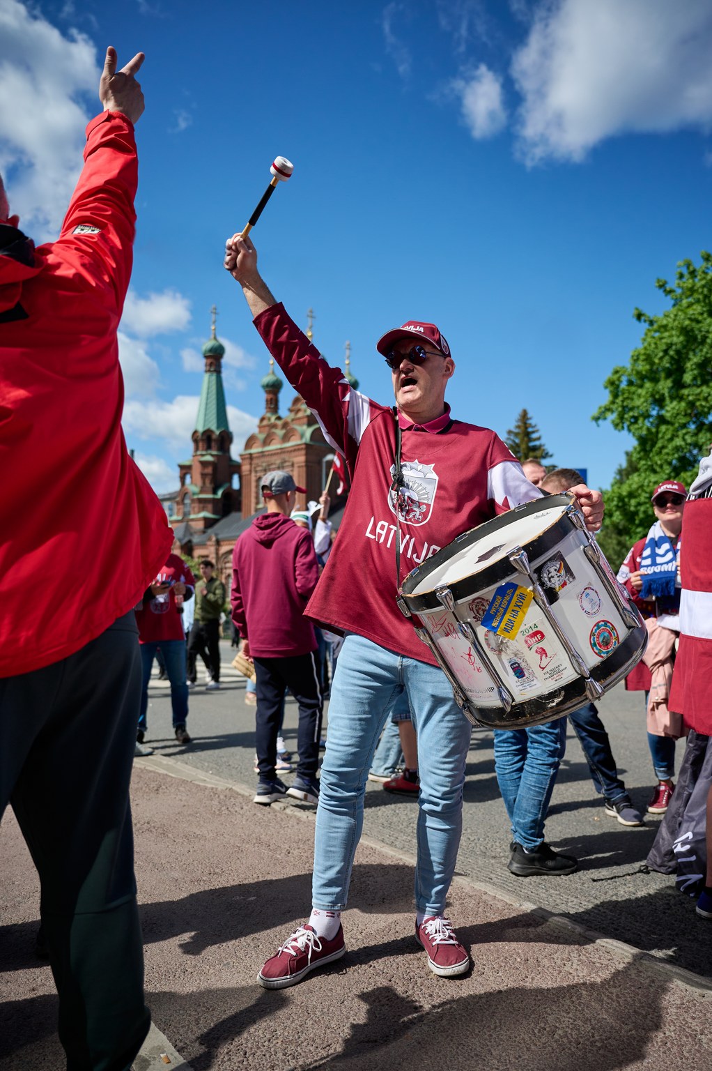 Latvian hockey fan beating with a drum.